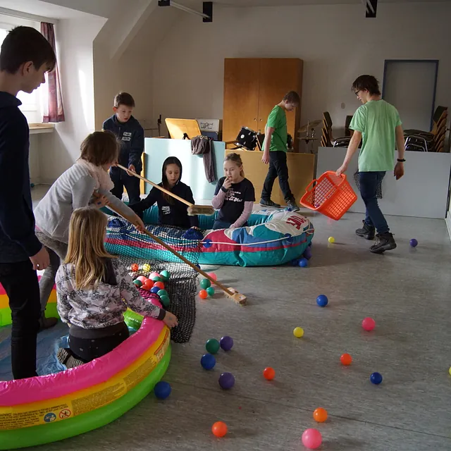 Die Kinder sind den Booten sammeln weiter Bälle. Die Bälle sind Fische.