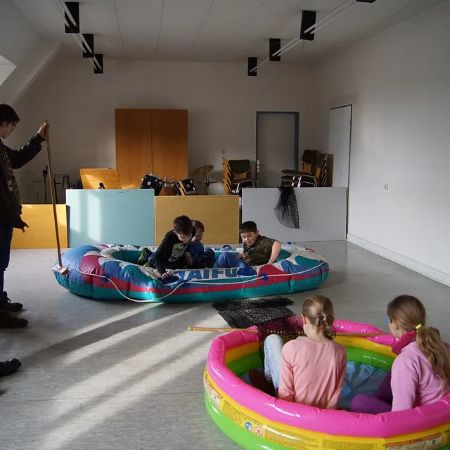 Station im Dachgeschoß: Kinder sitzen in Schlauchbooten