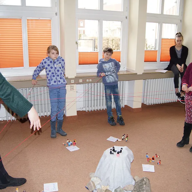 Kinder bei einem Fadenspiel