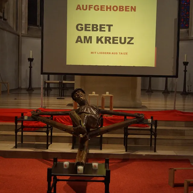 Das Coesfelder Kreuz vor dem Altarraum, im Hintergrund eine Leinwand für die Liedertexte