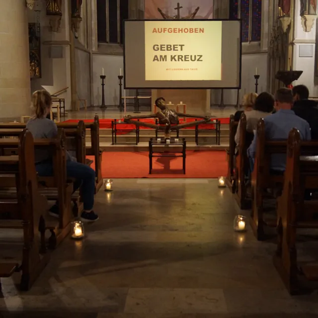 Blick auf den Altarraum und das Coesfelder Kreuz, im Vordergrund Gemeindemitglieder