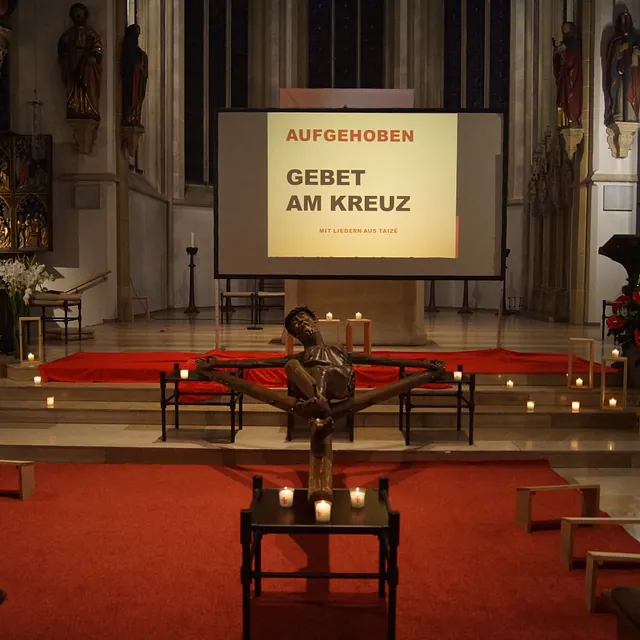 Blick auf das Coesfelder Kreuz und den Altarraum, im Hintergrund die Leinwand für die Liedertexte